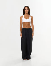 Front view of model wearing STAX. Stella Pants in black showing Toggle drawcord on leg opening and white sports bra