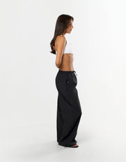 Side view of model wearing STAX. Stella Pants in black styled low waist with elastic and toggle drawstring 