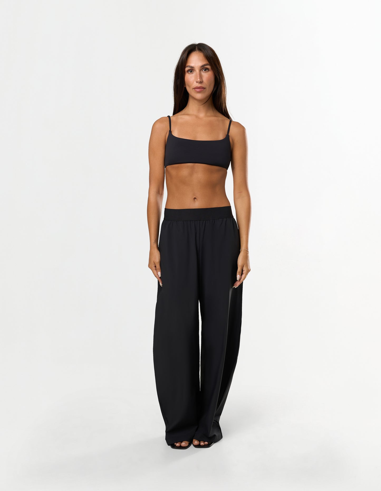 Front view of model wearing STAX. Gigi Pants in black showing outer elastic waistband design