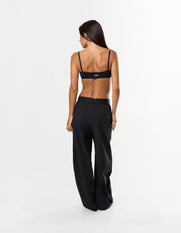 Back view of model wearing STAX. Gigi Pants in black showing outer elastic waistband design