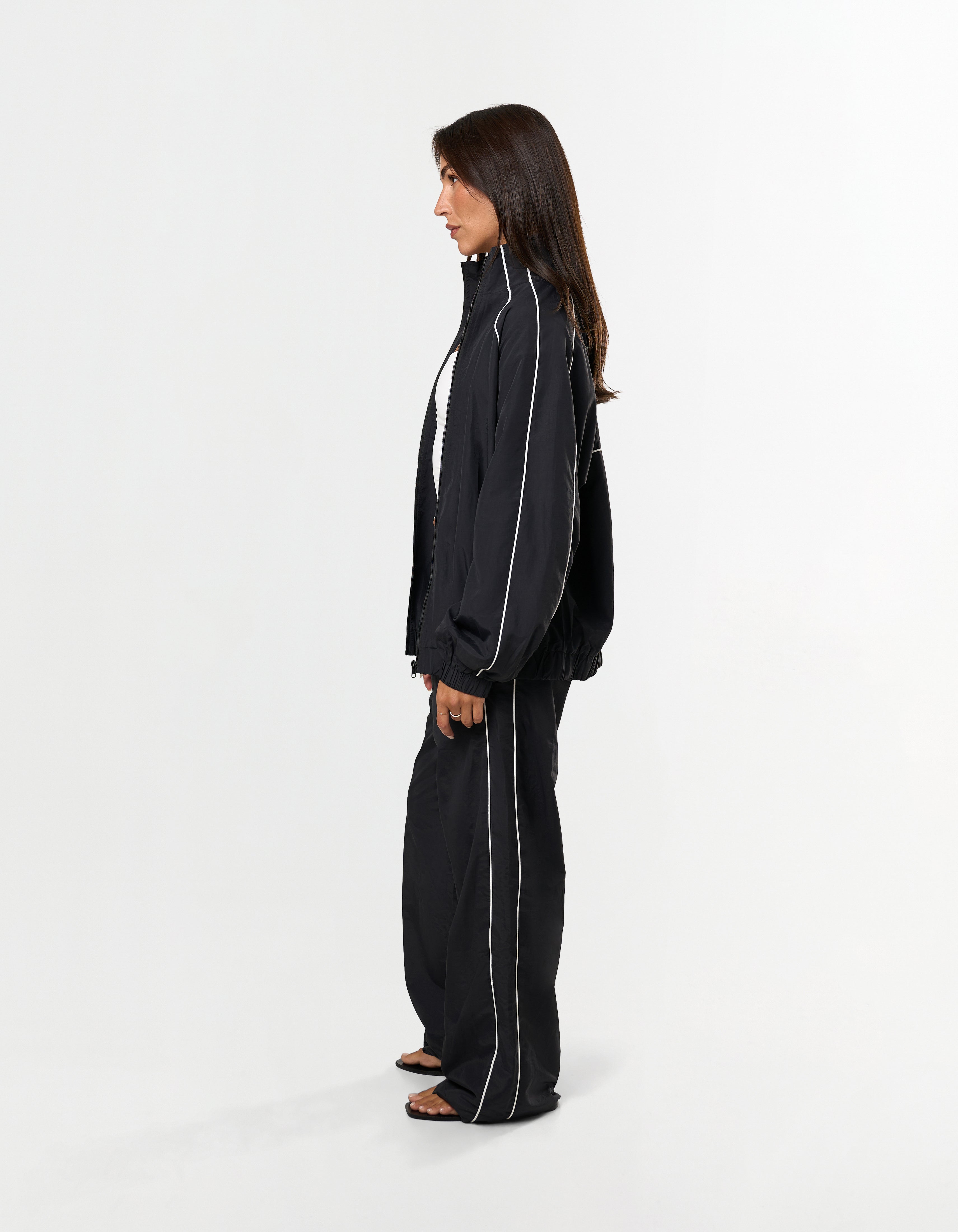Side profile of STAX. Woven Track Jacket showing contrast piping design