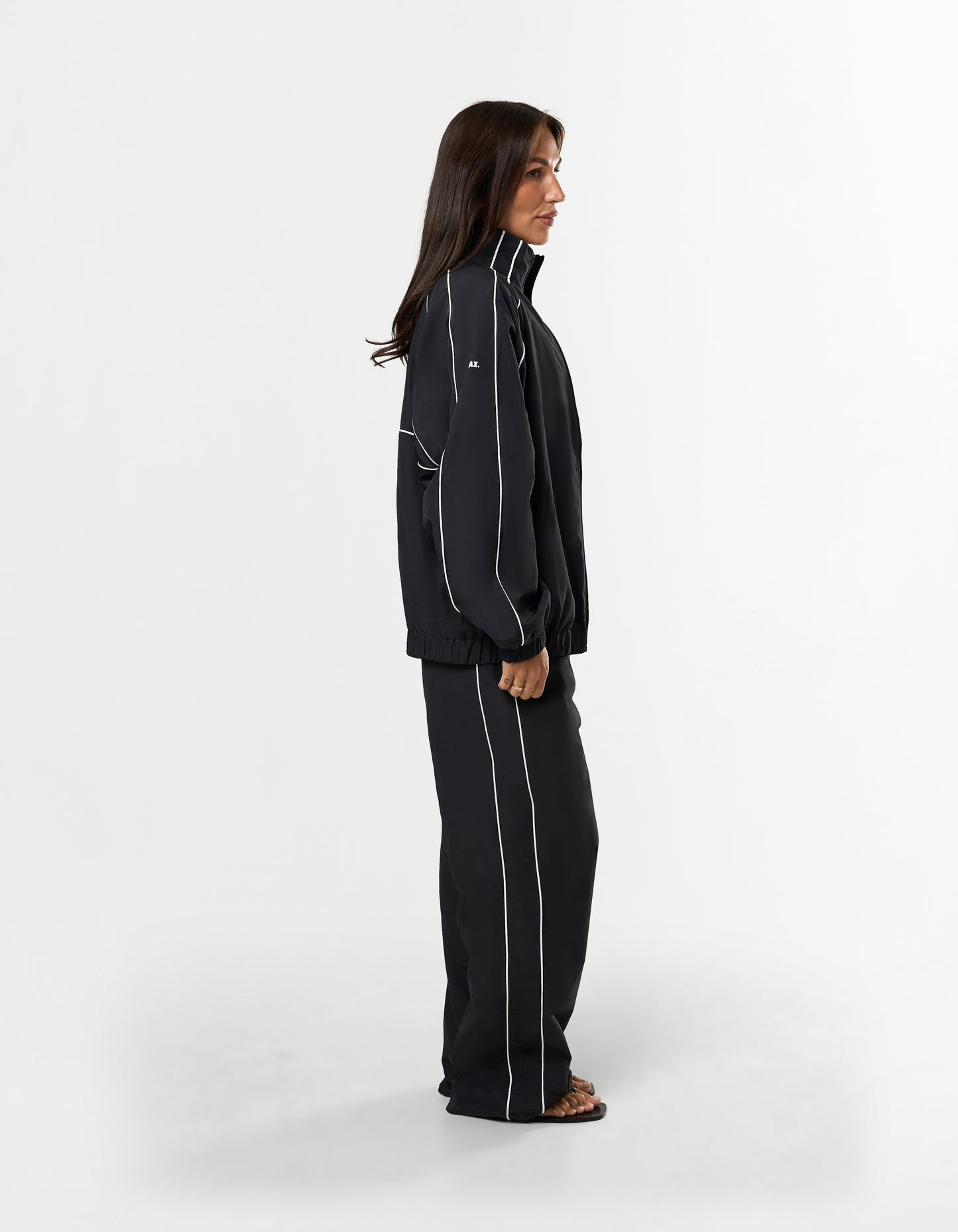 Side profile of STAX. Woven Track Pants and Track Jacket with contrast panelling and white logo detail 