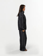 Side profile of STAX. Woven Track Pants and Track Jacket with contrast panelling and white logo detail 