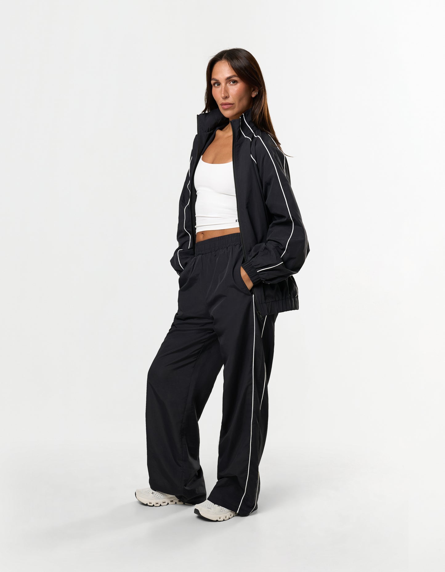 Front view of model wearing STAX. Woven Track Pants in Black with matching Woven Track Jacket