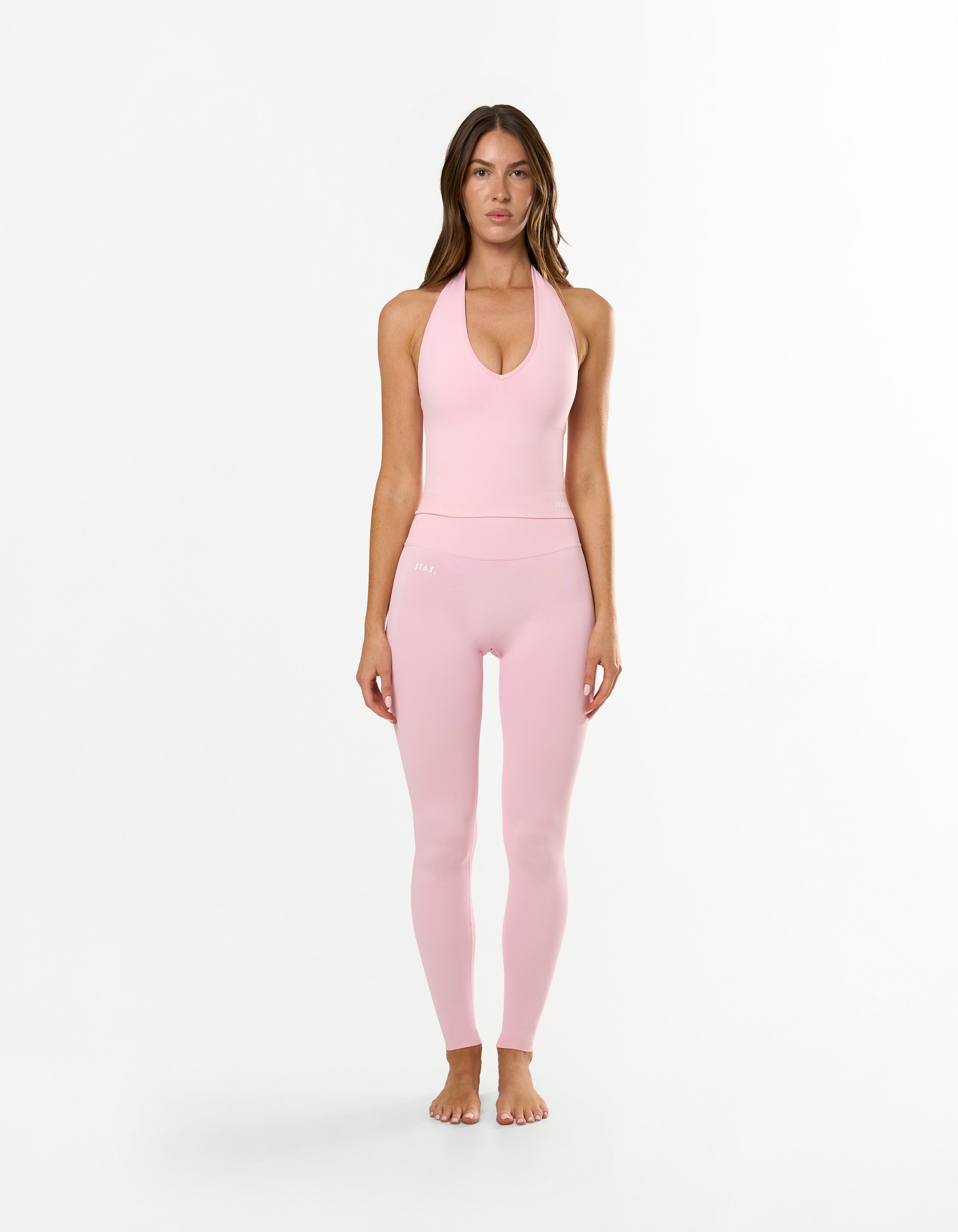 Front view of model wearing STAX. Premium Seamless Skulpt Midi Bike Shorts in Pink made from premium nylon spandex fabric with printed silicone logo 