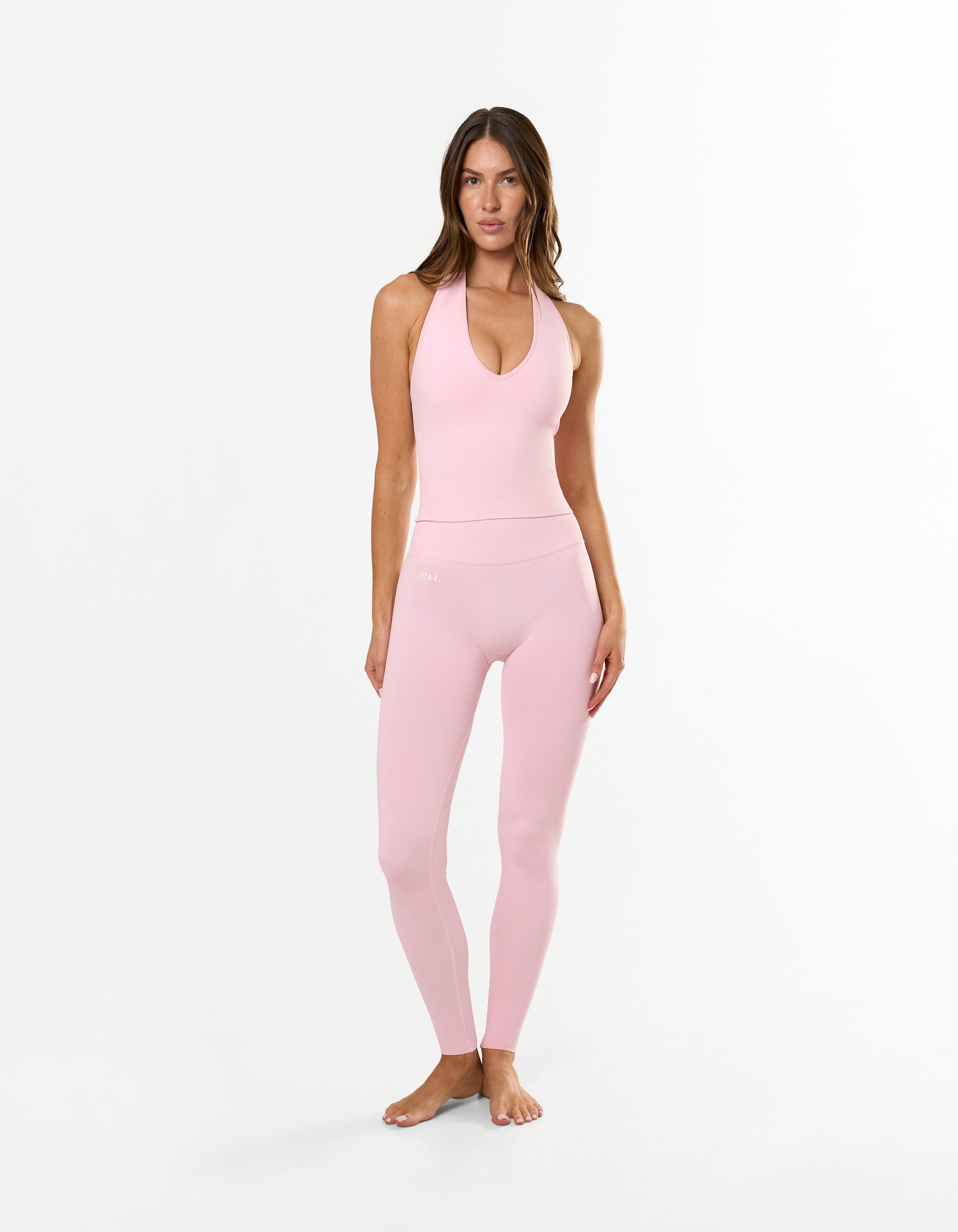 Front view of model wearing STAX. Premium Seamless Skulpt Leggings in Pink with matching skulpt halter tank in pink