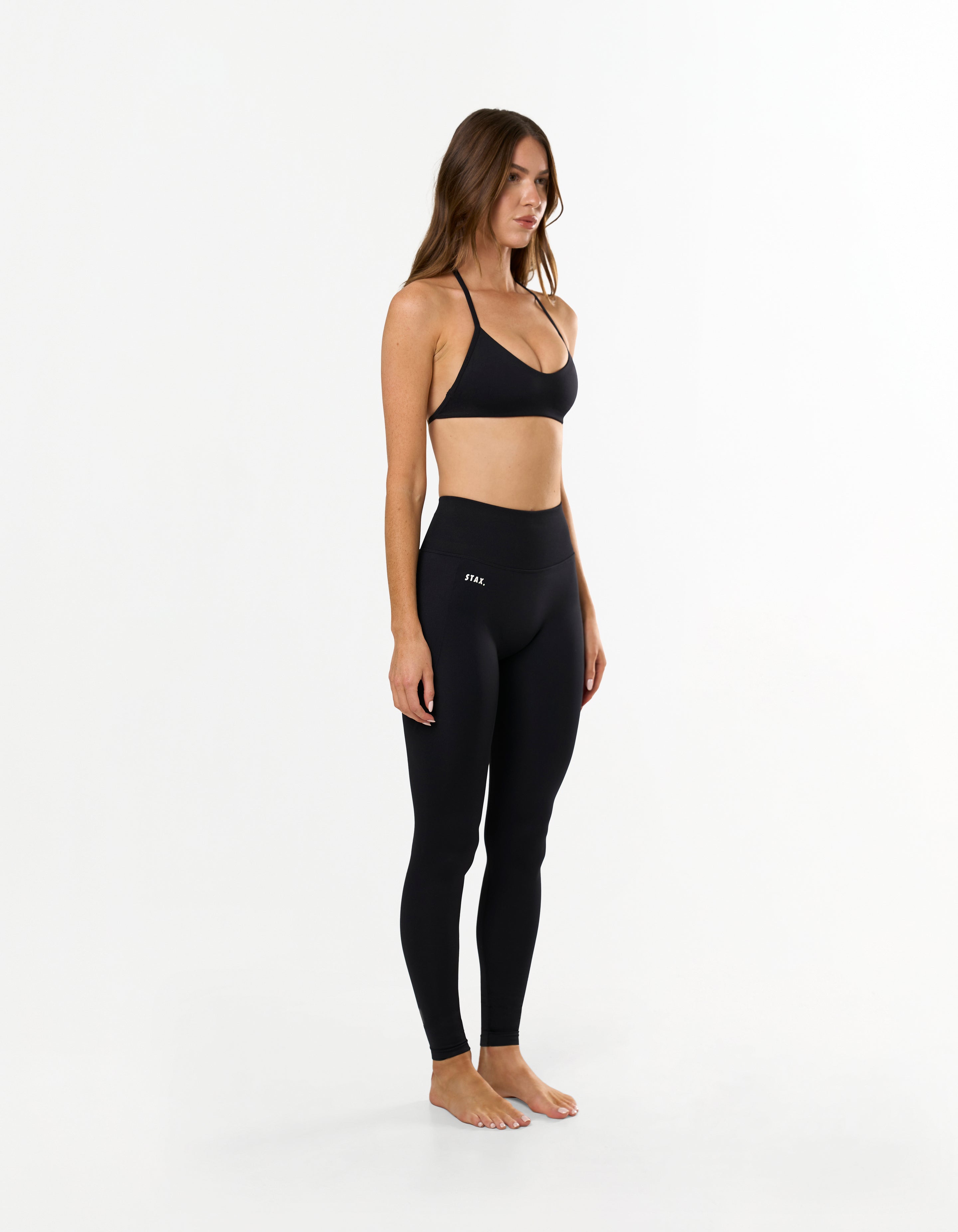 Front view of model wearing STAX. Premium Seamless Skulpt Tights in Black with matching skulpt bralette