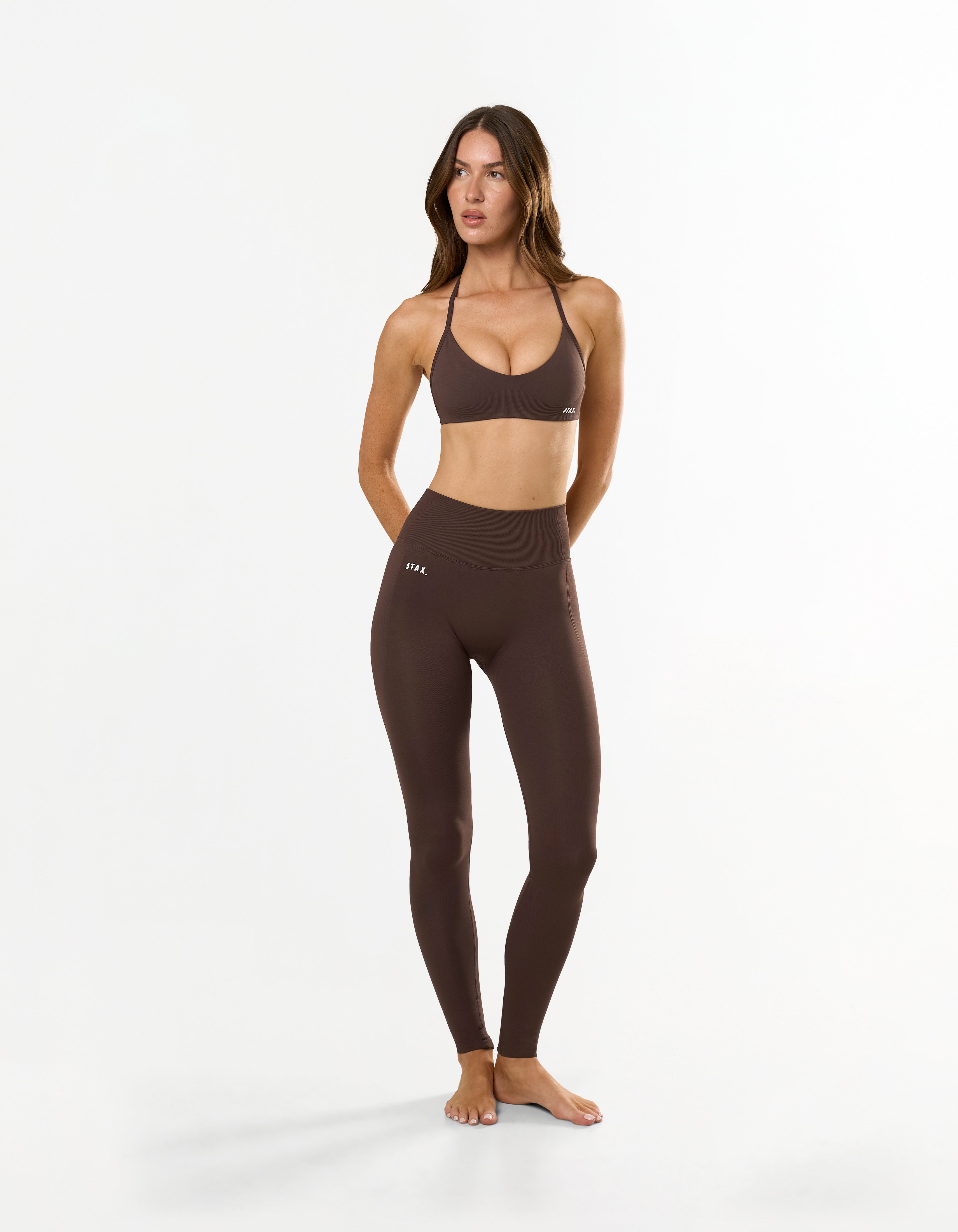 Front view of model wearing STAX. Premium Seamless Skulpt Tights in Brown premium nylon spandex fabric with printed silicone logo and compressive waistband 