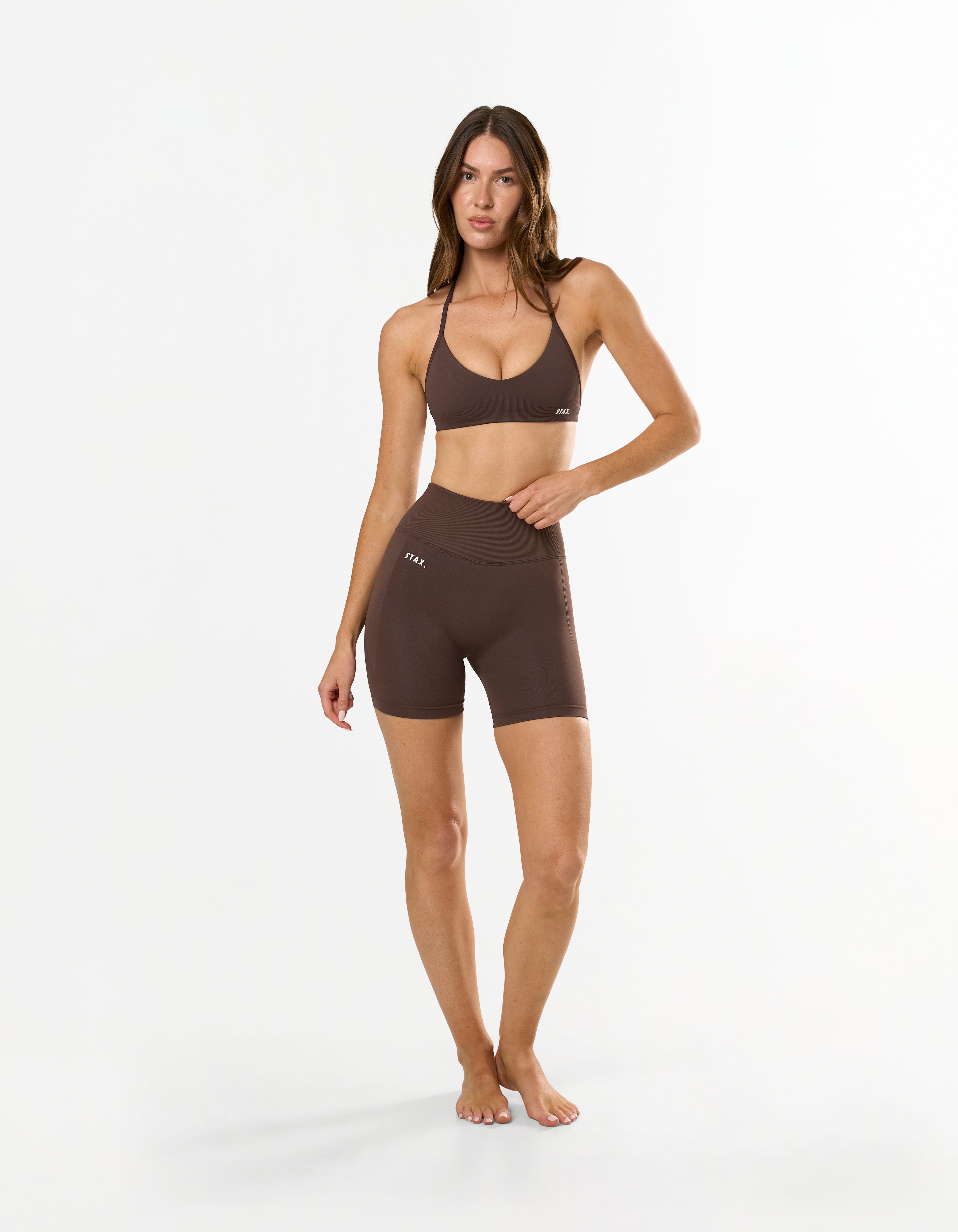 Front view of STAX. Premium Seamless Skulpt Bralette in Brown with matching skulpt midi bike shorts in Brown