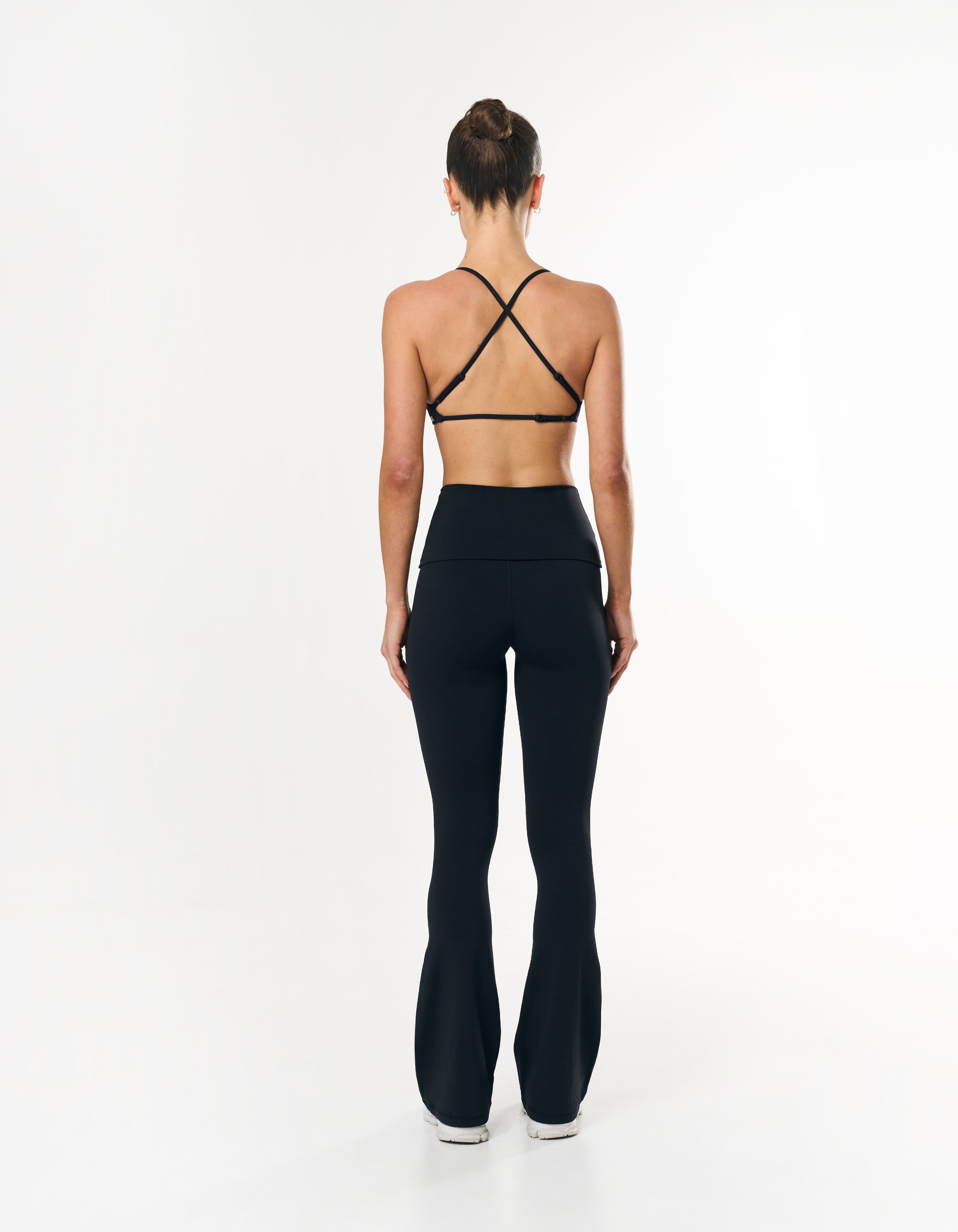 Back view of STAX. Fold over Flares in Black showing matching sports bra with crossover design 
