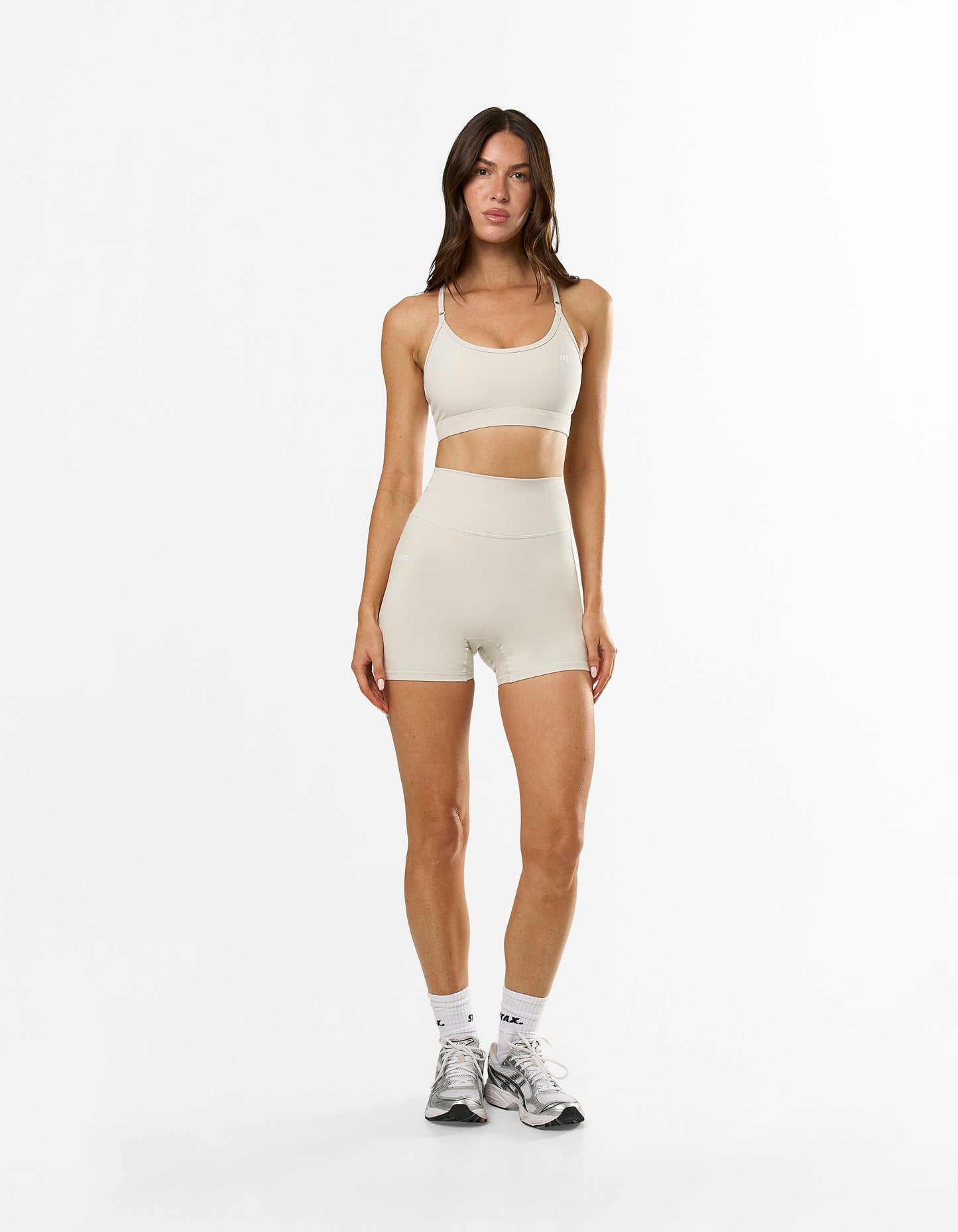 Front view of model wearing STAX. NFS Midi Bike Shorts NANDEX™ in Oat with matching Strappy Crop NANDEX™ in Oat 