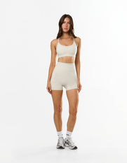 Front view of model wearing STAX. NFS Midi Bike Shorts NANDEX™ in Oat with matching Strappy Crop NANDEX™ in Oat 