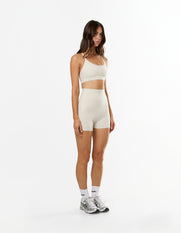 Side profile of STAX. NFS Midi Bike Shorts NANDEX™ in Oat showing flattering fit with no front seam