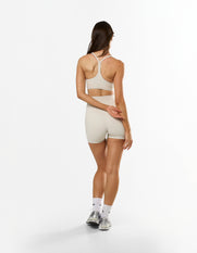 Back view of STAX. NFS Midi Bike Shorts NANDEX™ in Oat showing matching sports bra with racerback design 