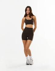 Front view of model wearing STAX. NFS (No Front Seam) Midi Bike Shorts NANDEX™ in Espresso with matching strappy crop NANDEX™