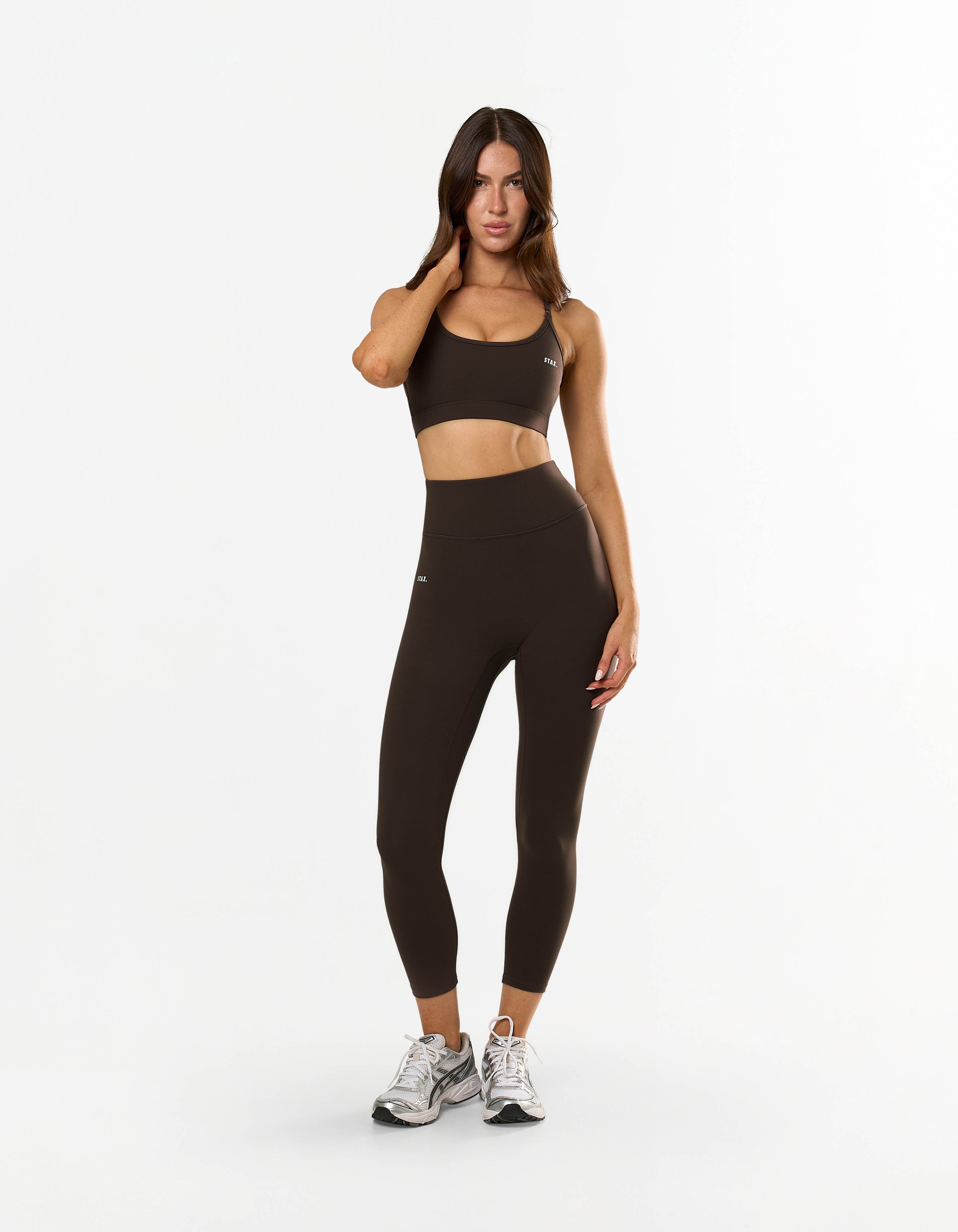 Front view of model wearing STAX. NFS (No Front Seam) 7/8 Tights NANDEX™ in Espresso with matching sports bra