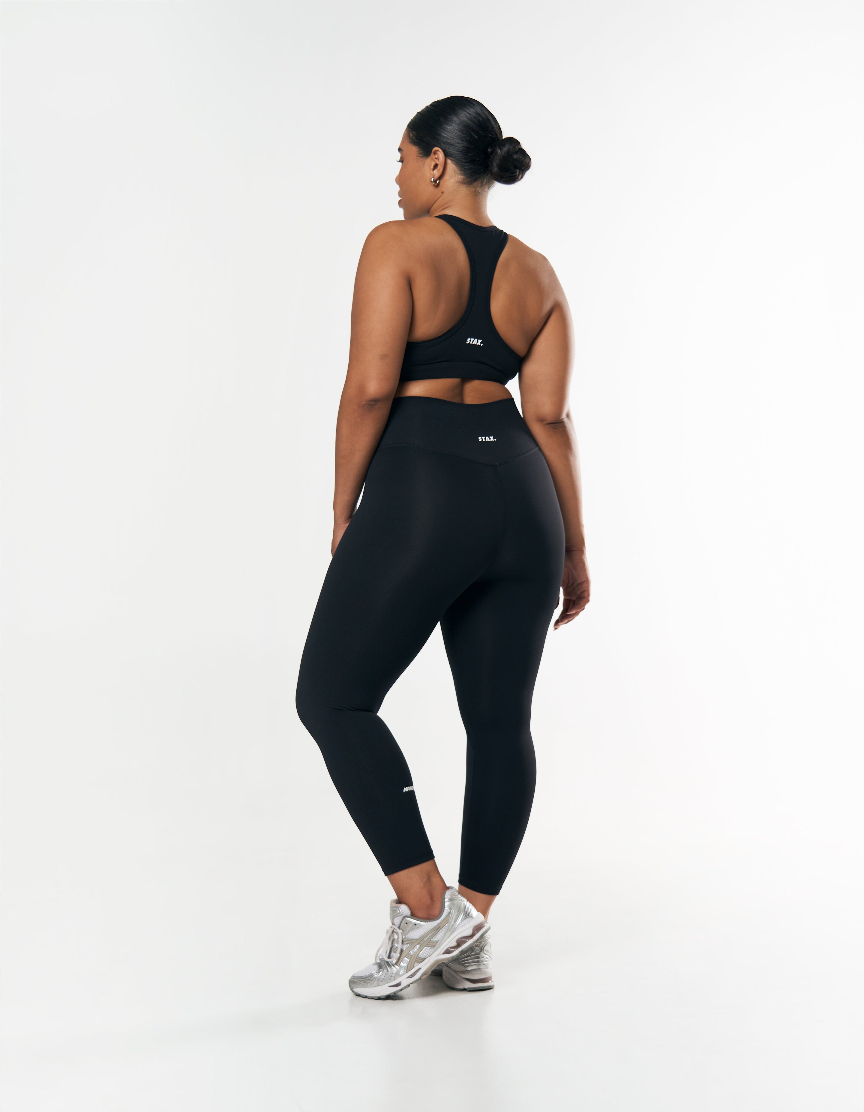 Back view of squat proof black gym leggings featuring V-back seam