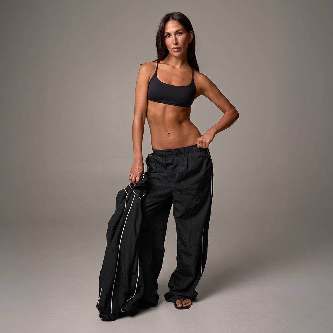 STAX. Women's New Arrivals - model wearing woven track set with matching Sports Bra - Shop Now