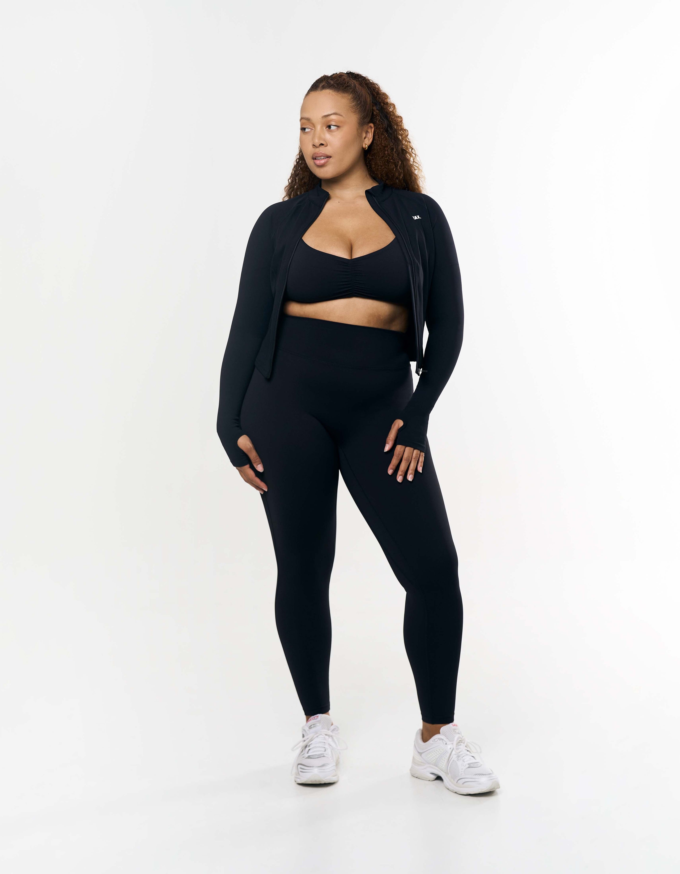 Front view of model wearing STAX. Active Zip Jacket Airlyte in Black with matching Sports bra and tights