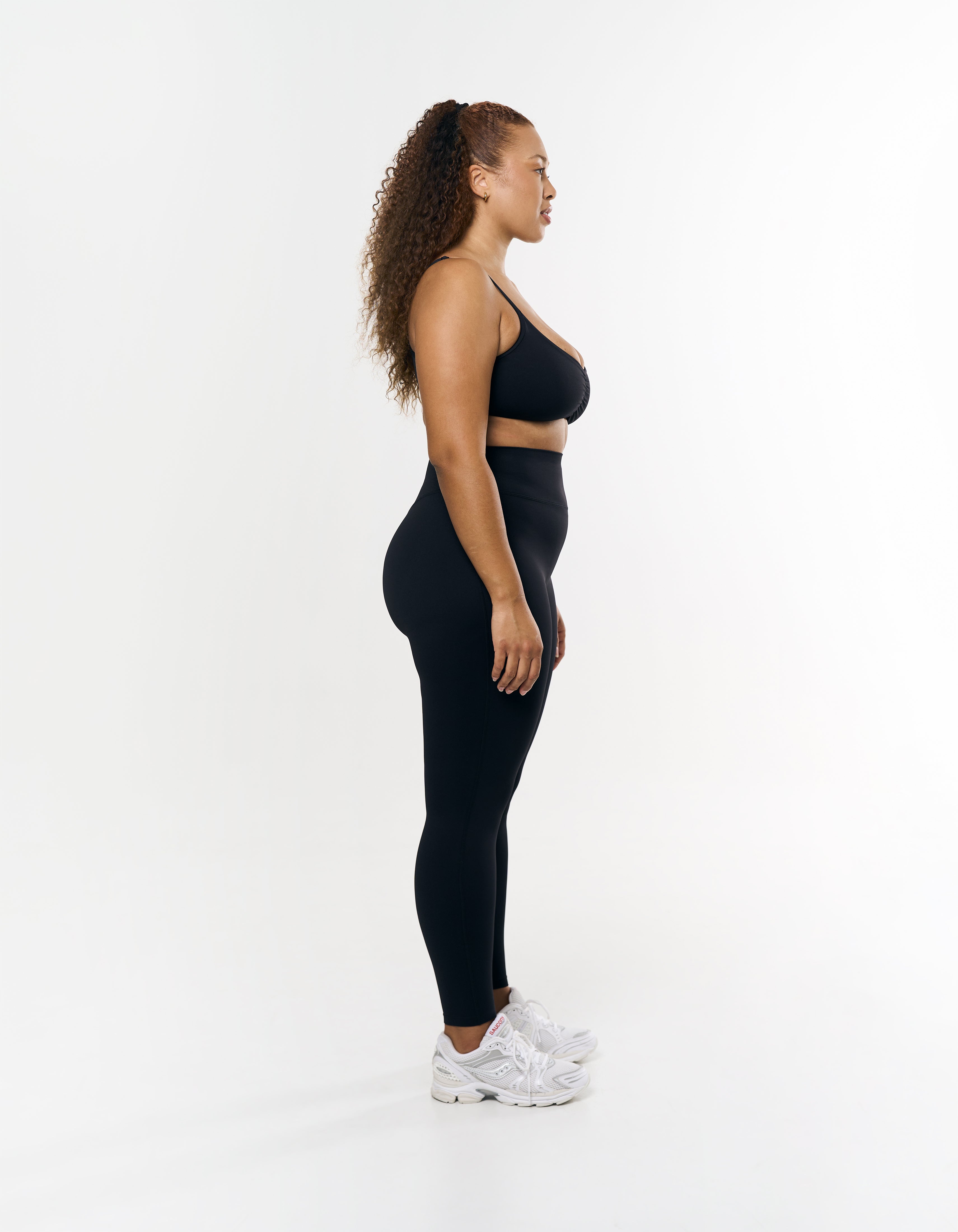 Side profile of STAX. Full Length Tights Airlyte in Black with matching sports bra showing ruched flattering design 