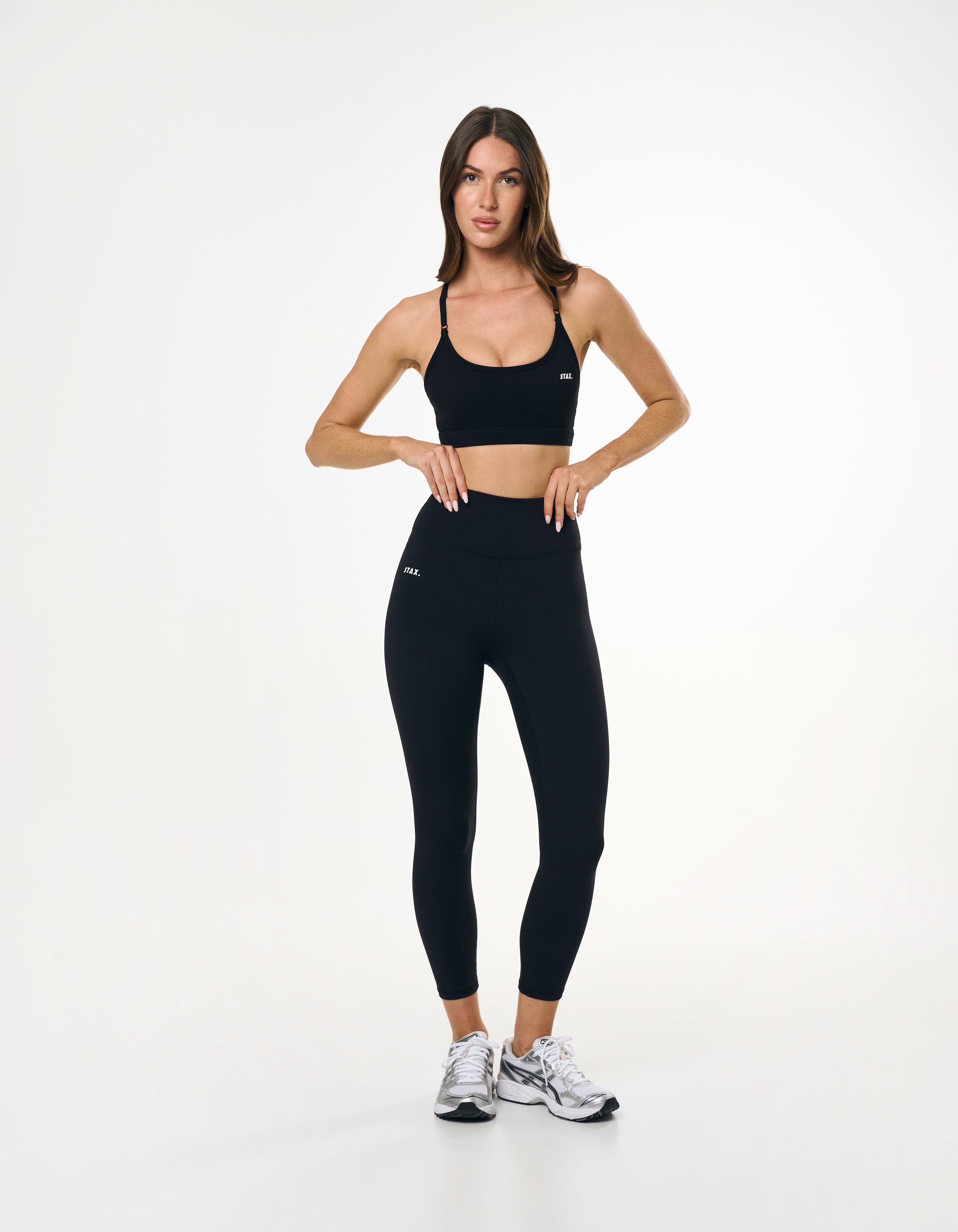 Front profile of model wearing high waisted black tights showing glute contour and seamless front