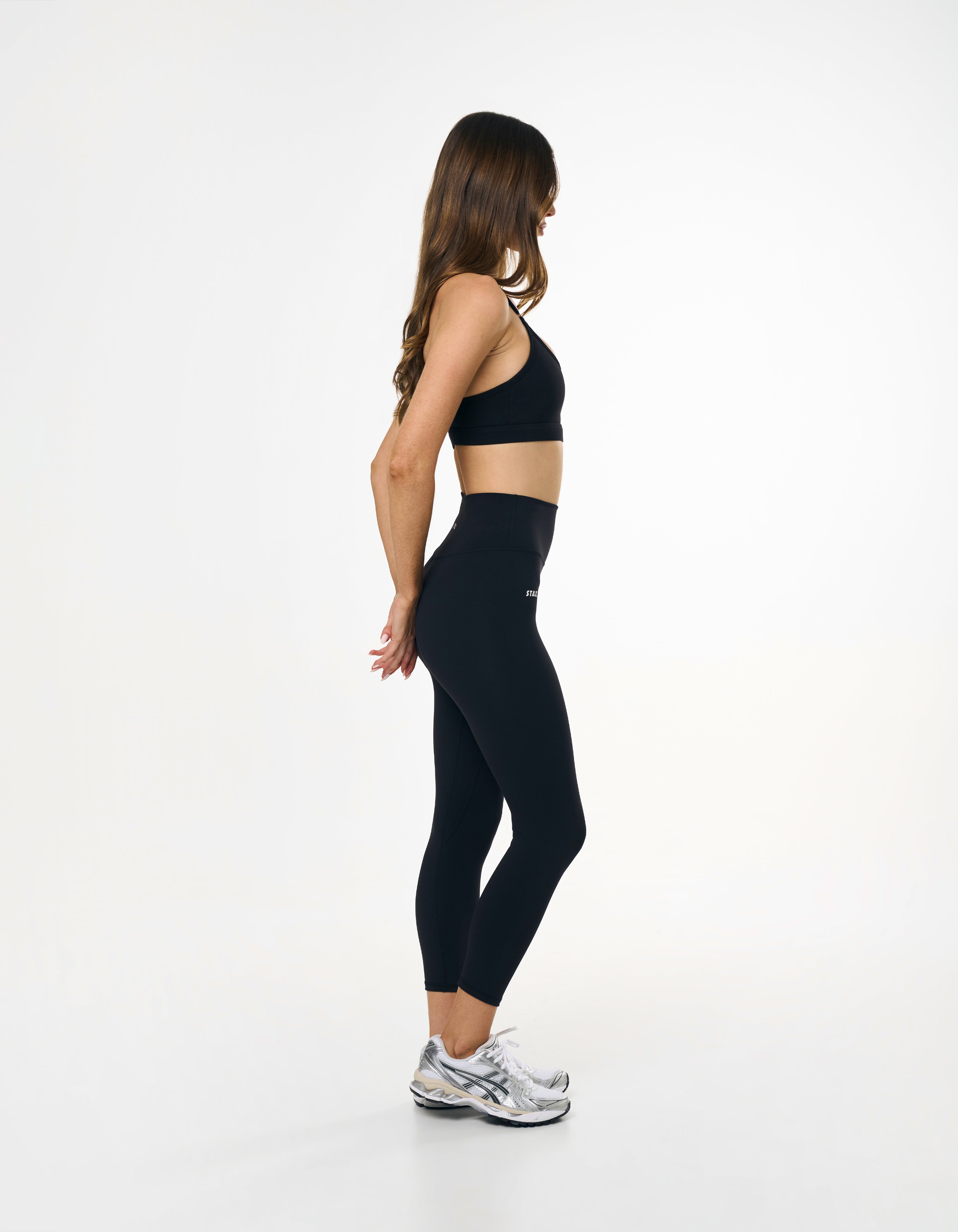 Side profile of high waisted black tights showing glute contour and seamless front